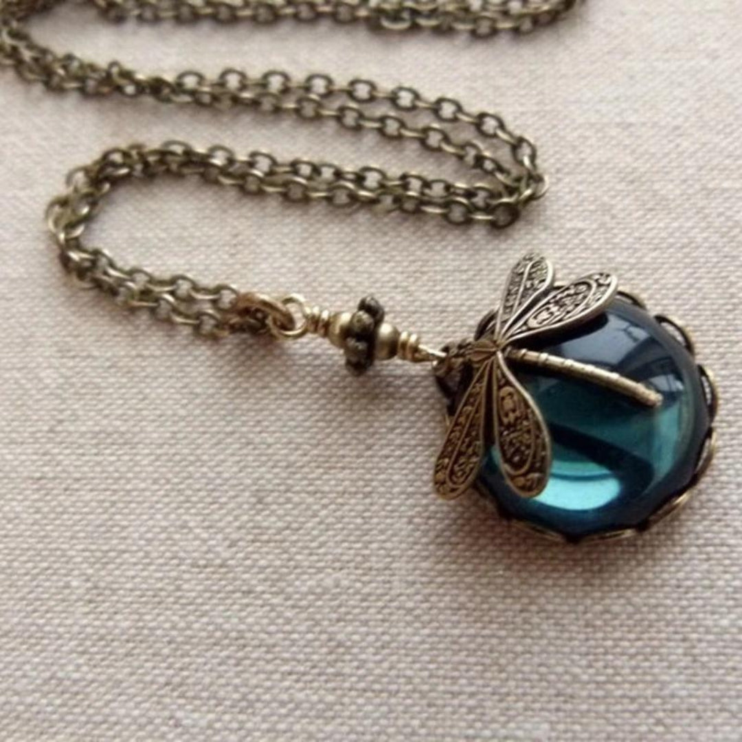 Vintage dragonfly necklace with ornate bronze chain and blue gemstone pendant, elegant jewelry accessory, antique style fashion statement.
