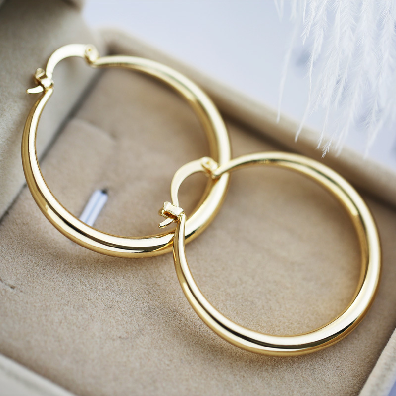 Gold hoop earrings in a jewelry box, elegant and shiny, perfect for fashion accessories, women's jewelry, and gift ideas.