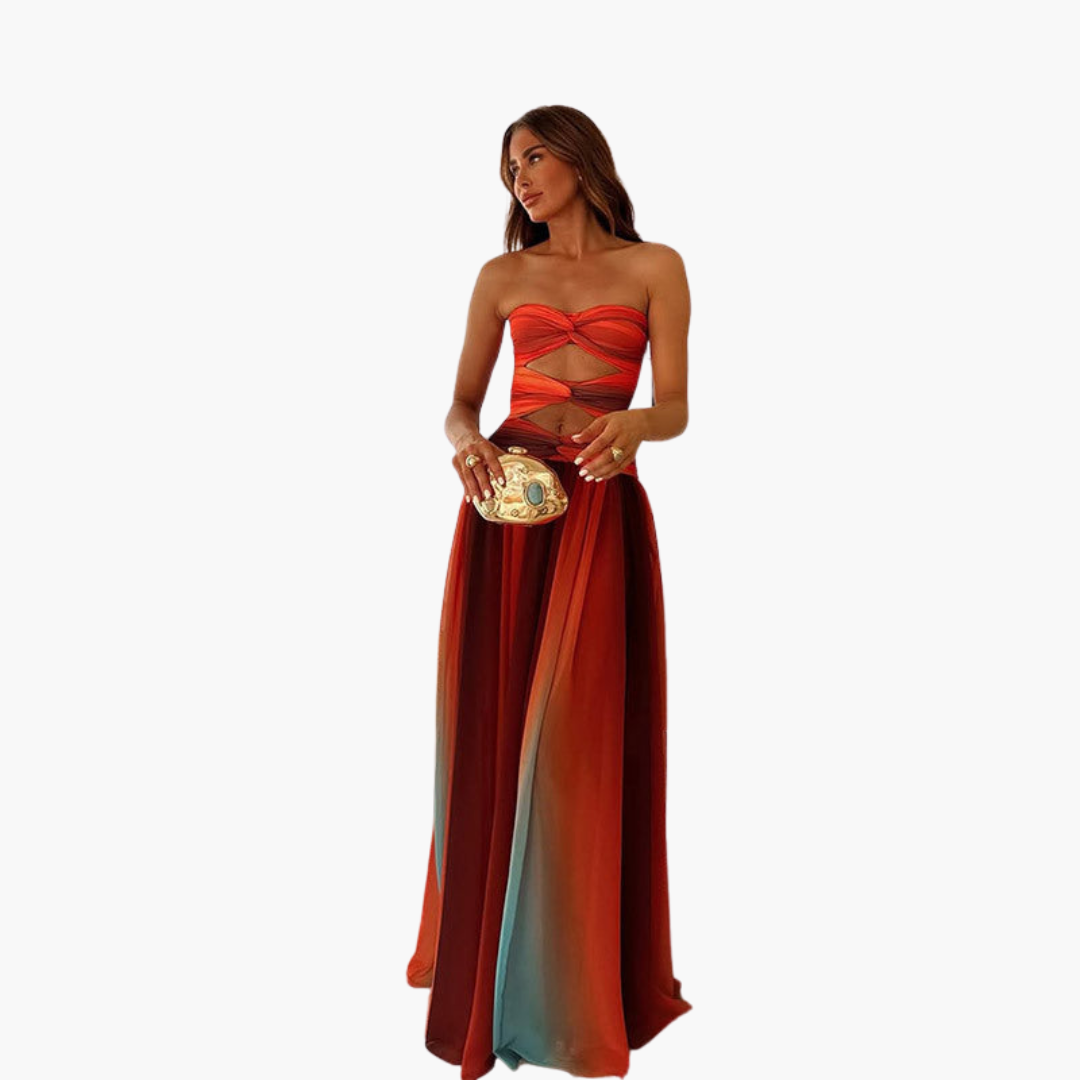 Woman wearing a strapless red and brown gradient dress holding a clutch on a white background