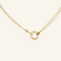 Gold Cartier Love necklace with diamond pendant, featuring iconic engraved design on a delicate chain. Luxury jewelry, elegant fashion accessory.