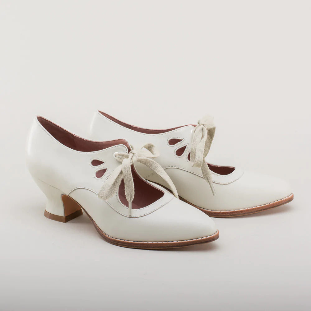 Pair of white shoes with brown soles on a light gray background