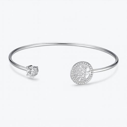Silver bangle bracelet featuring a tree of life charm and a sparkling cubic zirconia stone, minimalist jewelry, elegant wrist accessory.
