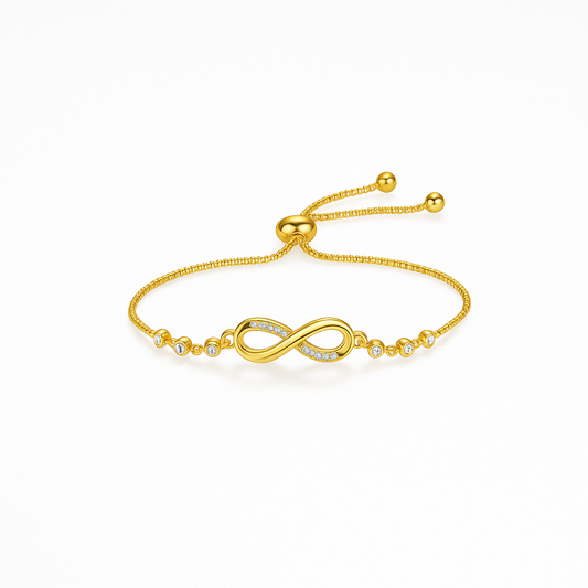 Gold infinity bracelet with adjustable chain and diamond accents on white background. Elegant jewelry, perfect for gifts and fashion accessories.