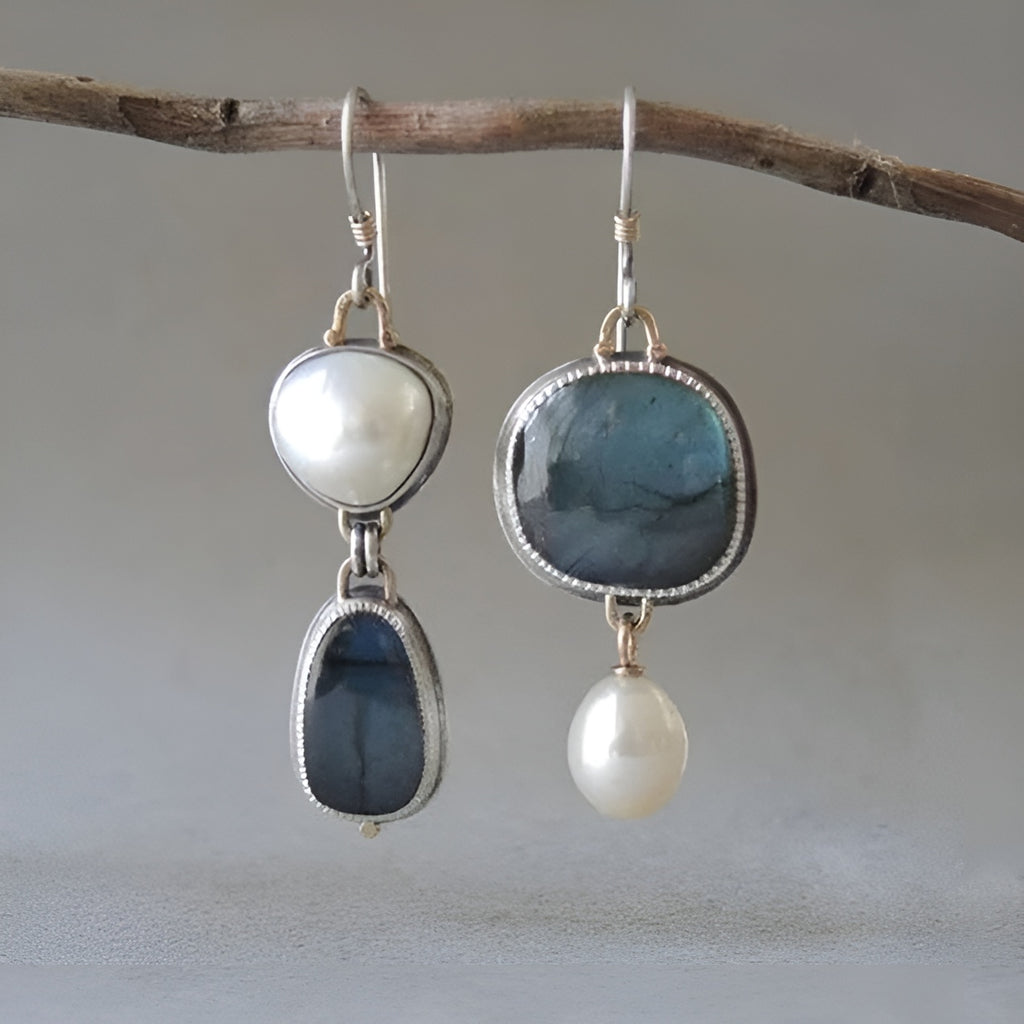 Elegant silver earrings with pearls and labradorite stones, hanging from a branch. Perfect for fashion, jewelry, and accessories keywords.