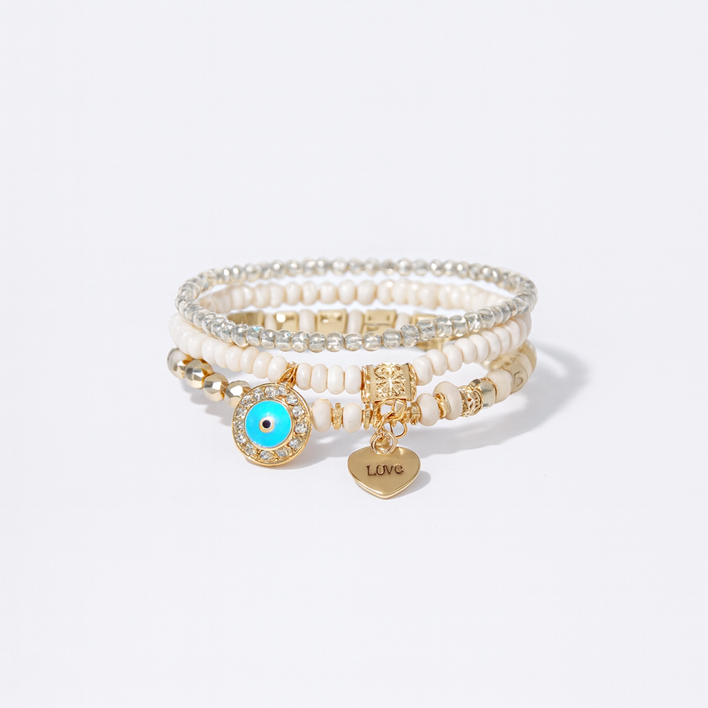 Stacked beaded bracelets with gold charms, including a blue evil eye and heart inscribed with "Love," on a white background. Fashion jewelry accessory.