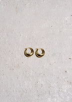 Gold hoop earrings on a light gray background