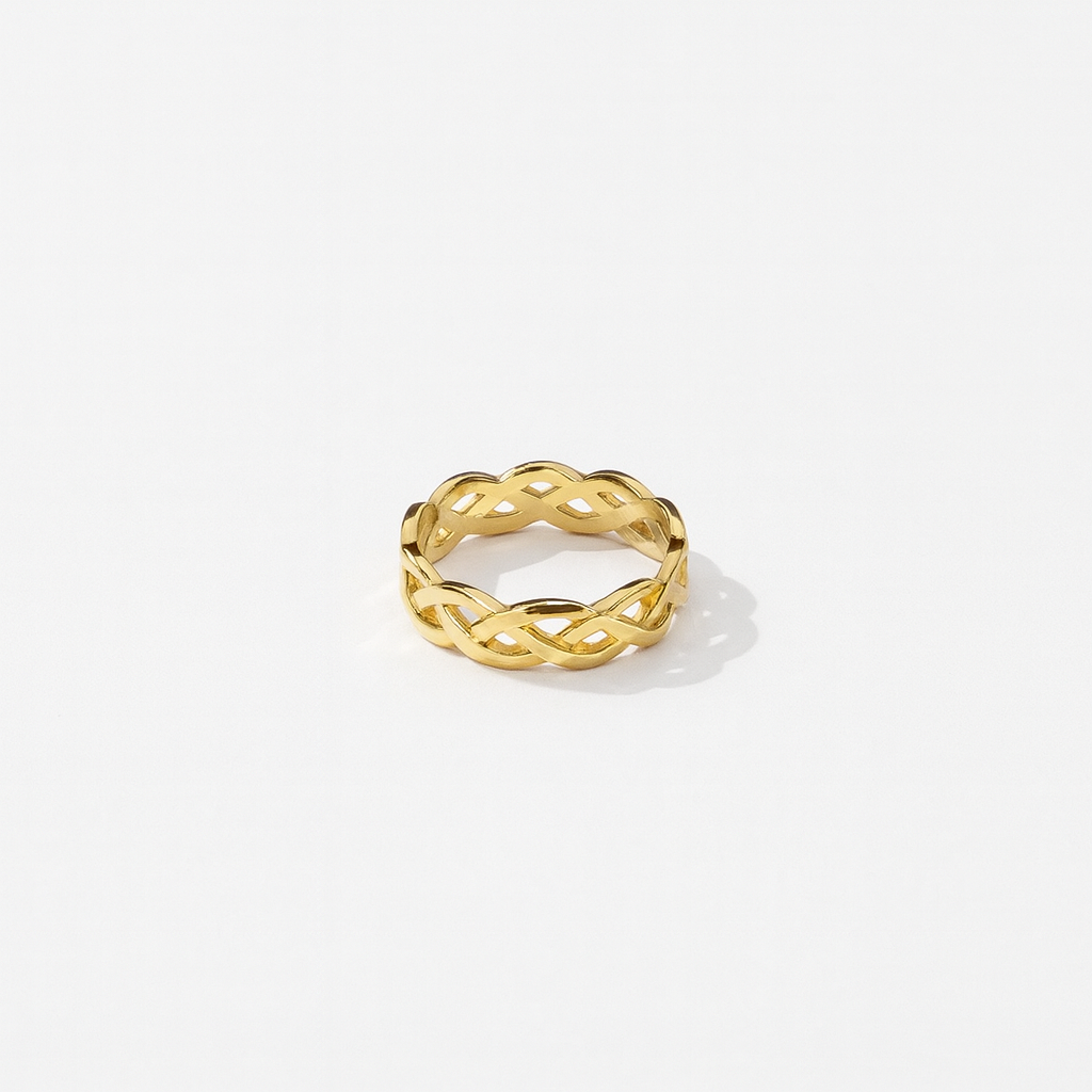 Gold ring with a braided design on a white background