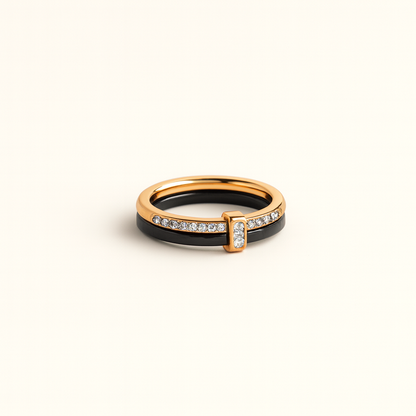 Gold and black ring with diamond accents on a beige background