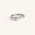 Silver ring with small diamonds on a light beige background