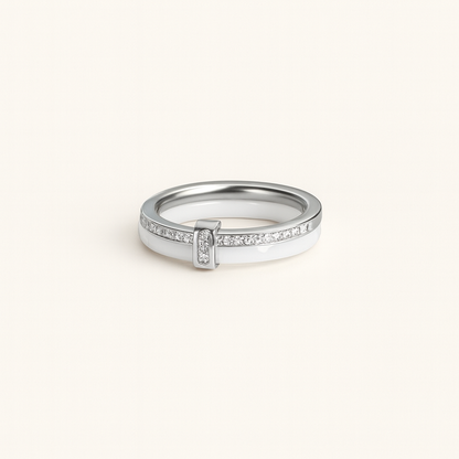 Silver ring with small diamonds on a light beige background
