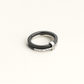 Two rings, one black and one silver with diamonds, on a white background