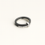 Two rings, one black and one silver with diamonds, on a white background