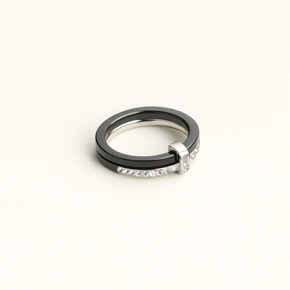 Two rings, one black and one silver with diamonds, on a white background