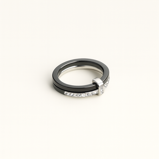 Two rings, one black and one silver with diamonds, on a white background