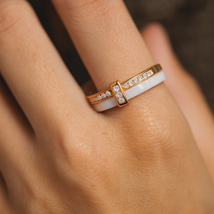 Gold and white ring on a person's finger with a blurred background