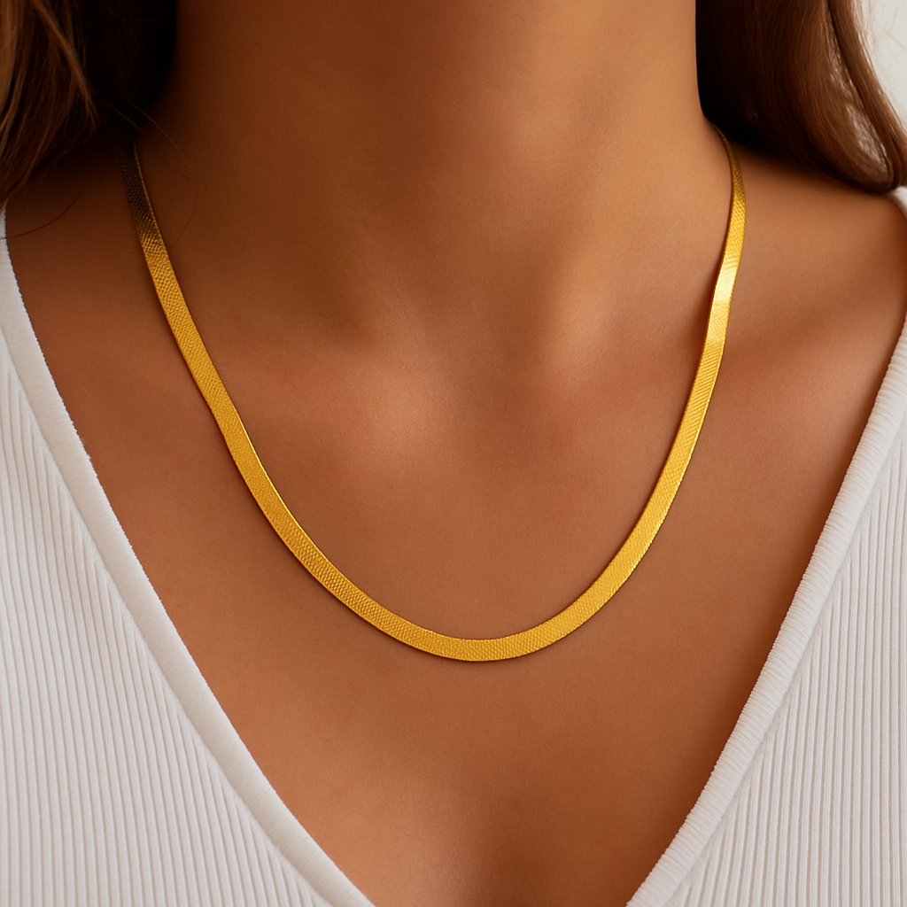 Gold herringbone necklace on woman wearing white ribbed top, close-up. Elegant jewelry, fashion accessory, minimalist style.