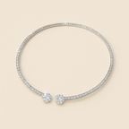 Elegant diamond-studded open bangle bracelet with two large round diamonds, luxury jewelry, sparkling gemstones, minimalist design on beige background.
