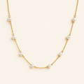 Gold chain necklace with evenly spaced white pearls, elegant jewelry design, minimalist style, perfect for fashion accessories and gift ideas.