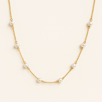 Gold chain necklace with evenly spaced white pearls, elegant jewelry design, minimalist style, perfect for fashion accessories and gift ideas.