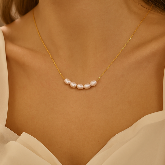 Elegant gold necklace with five white pearls on a woman's neck, showcasing luxury jewelry fashion, perfect for bridal or formal occasions.