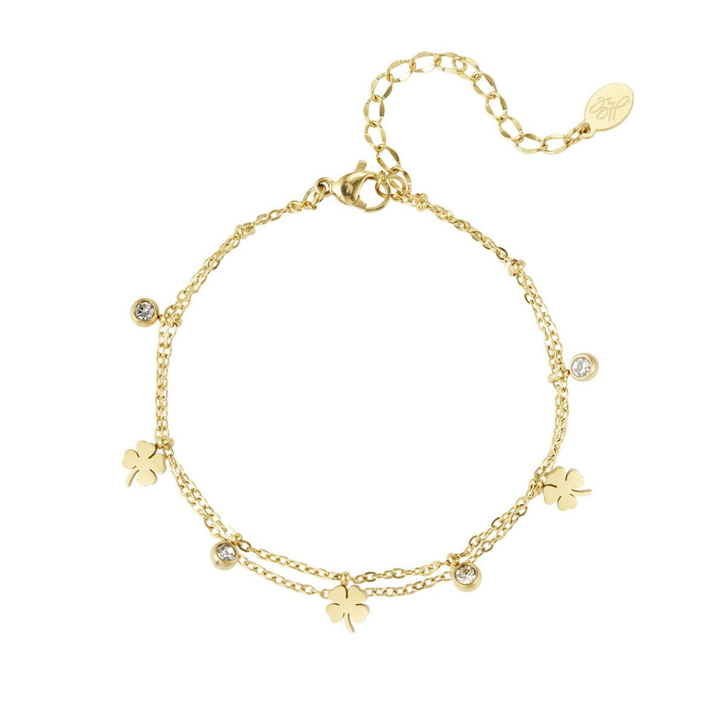 Gold bracelet with clover charms on a white background