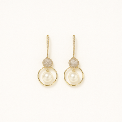 Elegant gold drop earrings with sparkling crystals and round pearls, perfect for weddings or formal events. Luxurious jewelry accessory.