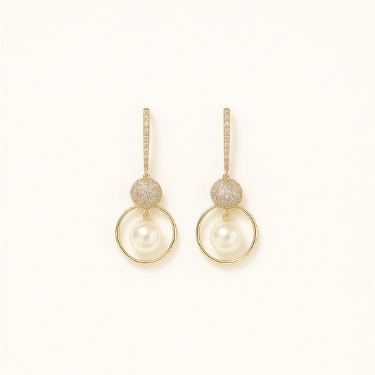 Elegant gold drop earrings with sparkling crystals and round pearls, perfect for weddings or formal events. Luxurious jewelry accessory.