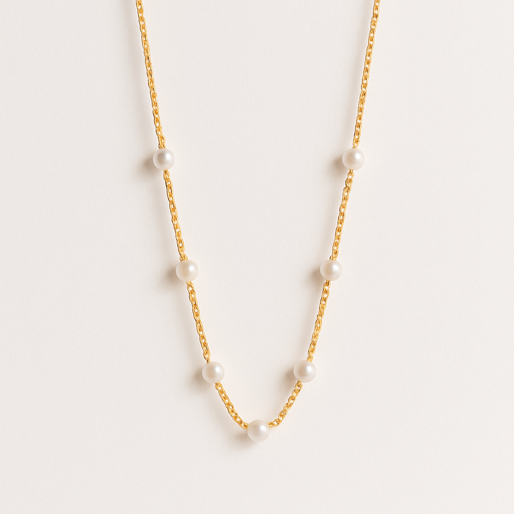 Gold chain necklace with evenly spaced white pearls, minimalist jewelry design, elegant fashion accessory, perfect for formal occasions.