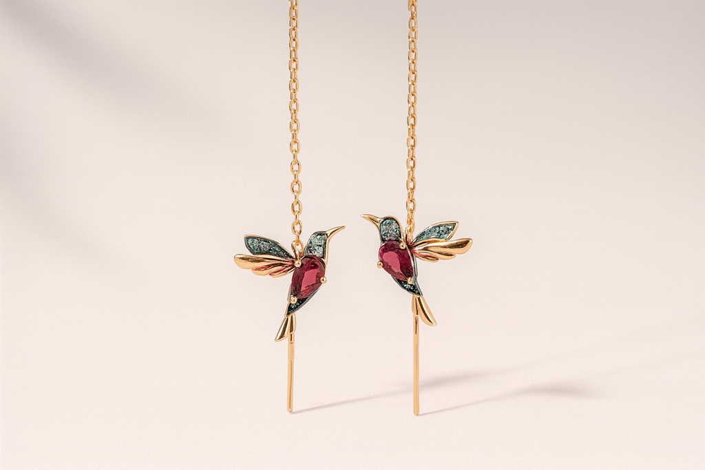 Gold hummingbird earrings with red and blue gemstones, featuring intricate design and delicate chain, perfect for elegant jewelry fashion.