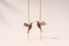 Gold hummingbird earrings with red and blue gemstones, featuring intricate design and delicate chain, perfect for elegant jewelry fashion.
