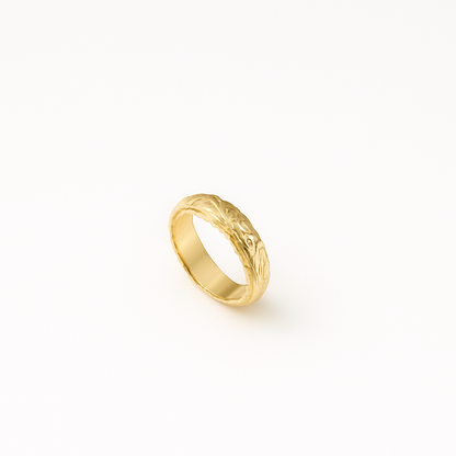 Gold wedding band with intricate floral engraving on a white background. Elegant and timeless design, perfect for engagements or anniversaries.
