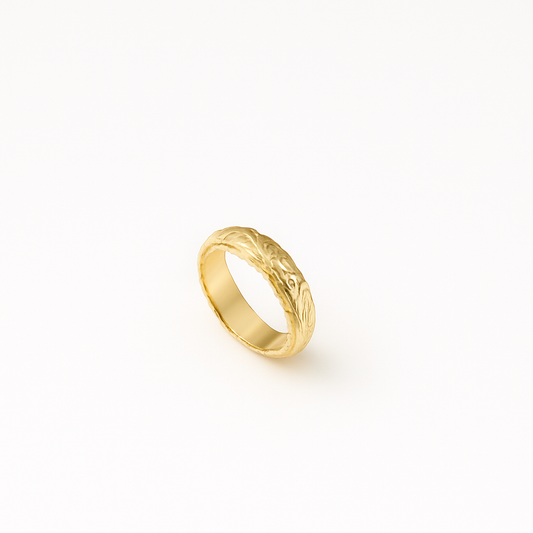 Gold wedding band with intricate floral engraving on a white background. Elegant and timeless design, perfect for engagements or anniversaries.