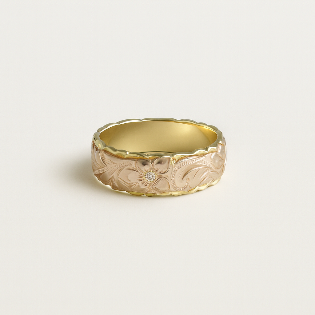 Gold ring with floral engraving on a light beige background