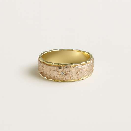Gold ring with floral engraving on a light beige background