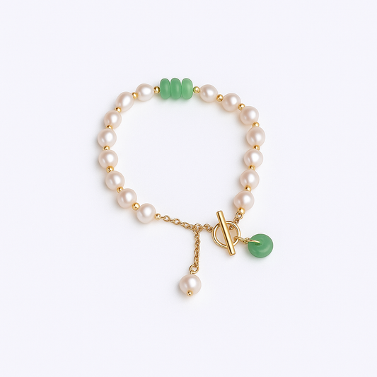 Elegant pearl bracelet with gold chain, green jade accents, and toggle clasp. Luxurious jewelry, perfect for fashion accessories and gift ideas.
