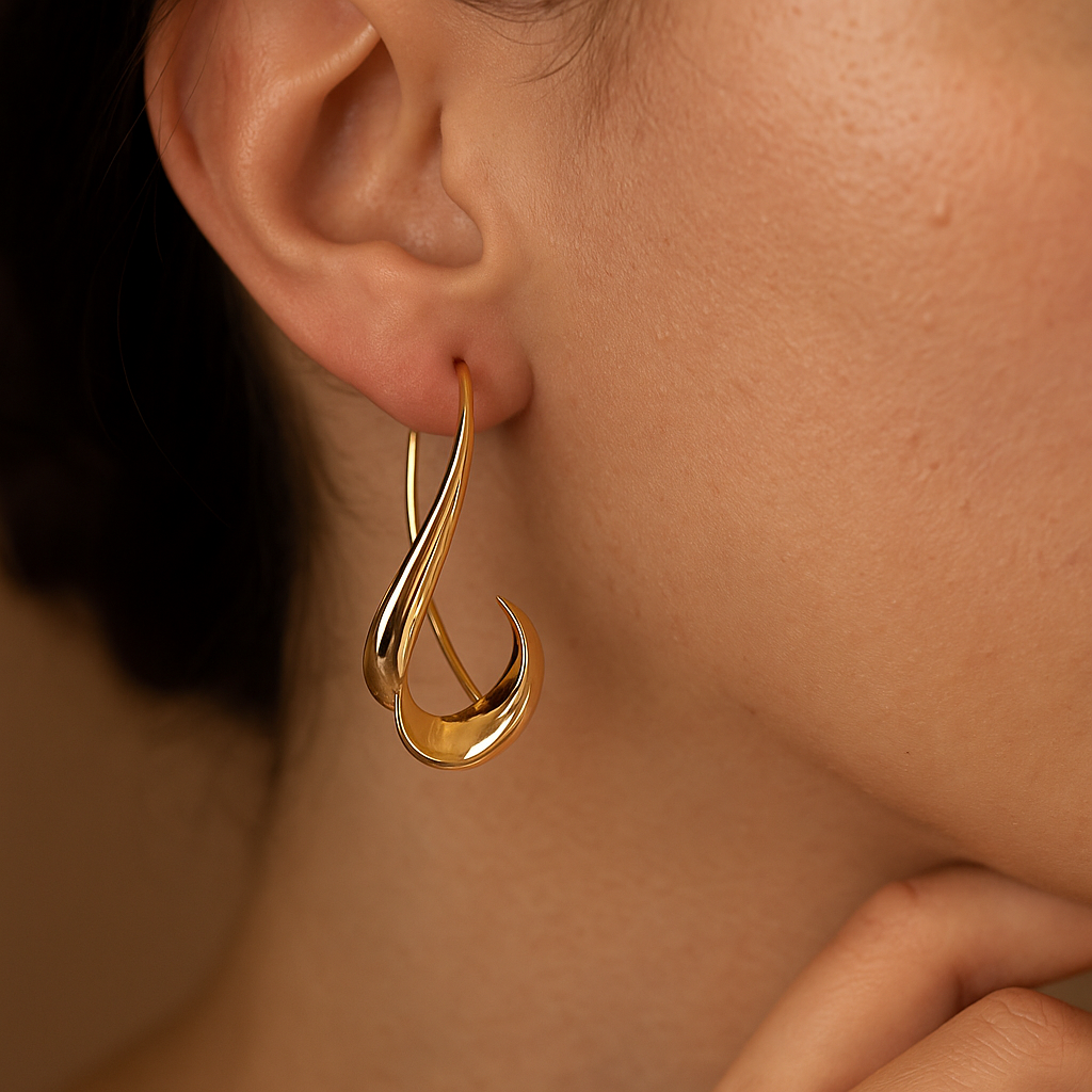 Close-up of a person wearing a gold earring with a blurred background