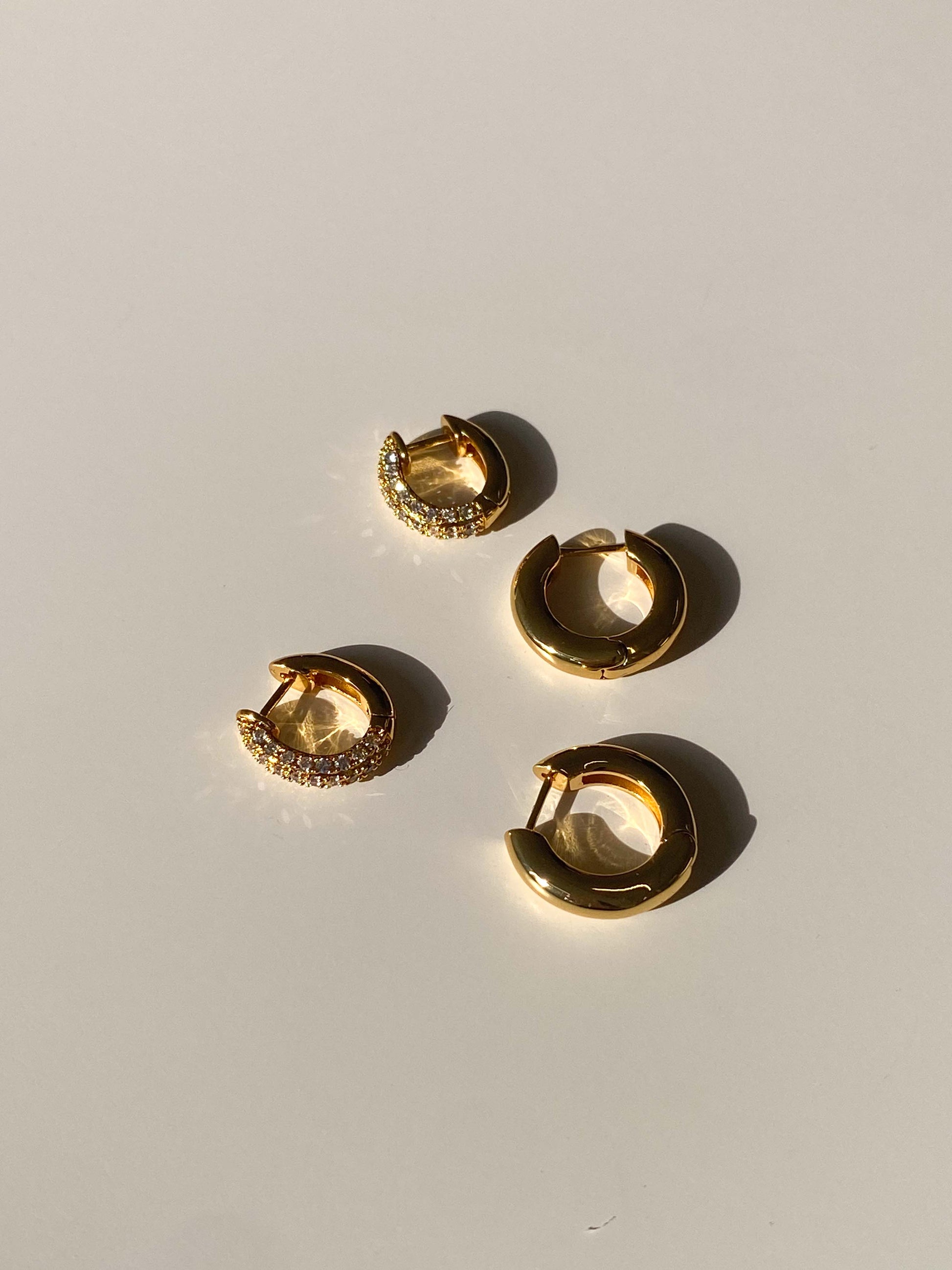 Gold hoop earrings on a light gray background