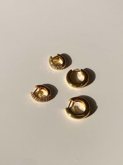 Gold hoop earrings on a light gray background