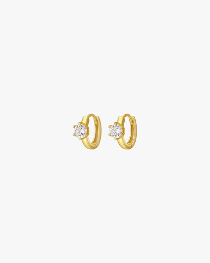 Gold hoop earrings with sparkling diamond accents on a white background, elegant jewelry, women's fashion accessories, luxury style.