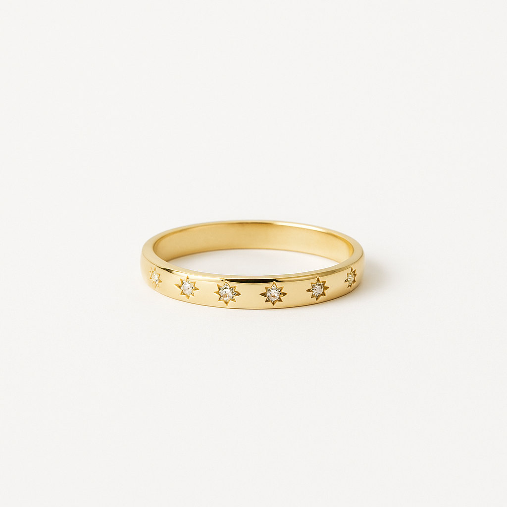 Gold ring with star-shaped gemstones on a white background