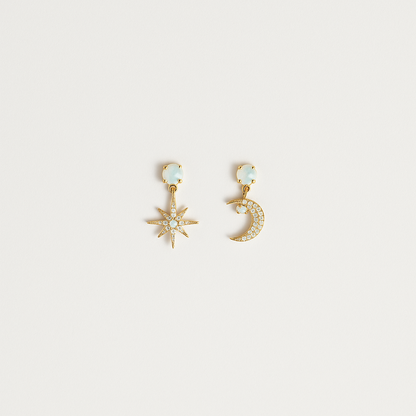 Gold star and moon earrings with crystal accents on a white background. Celestial jewelry, fashion accessories, elegant design.