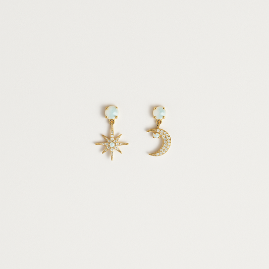 Gold star and moon earrings with crystal accents on a white background. Celestial jewelry, fashion accessories, elegant design.