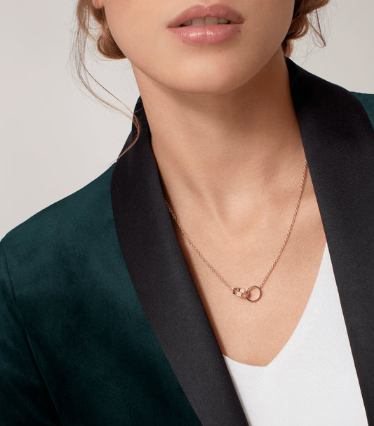 Person wearing a delicate necklace with a minimal background