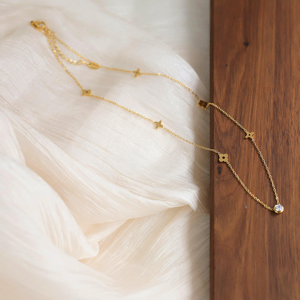 Gold necklace with star-shaped pendants on a soft fabric background