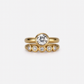Gold ring with diamond on a light gray background