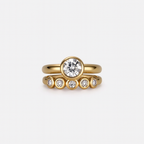 Gold ring with diamond on a light gray background