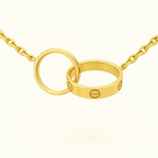Gold chain necklace with two interlocking rings, featuring a screw motif. Elegant jewelry design, luxury fashion accessory, minimalist style.