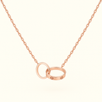 Rose gold necklace with interlocking rings pendant, featuring a delicate chain. Elegant jewelry piece, perfect for weddings or anniversaries.