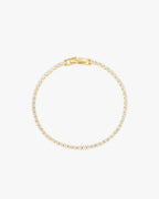 Gold tennis bracelet with round-cut diamonds, elegant clasp, and minimalist design on a white background. Perfect for luxury jewelry enthusiasts.