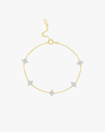 Gold bracelet with star-shaped charms on a light gray background